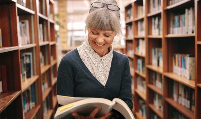 a woman reading a book in a library